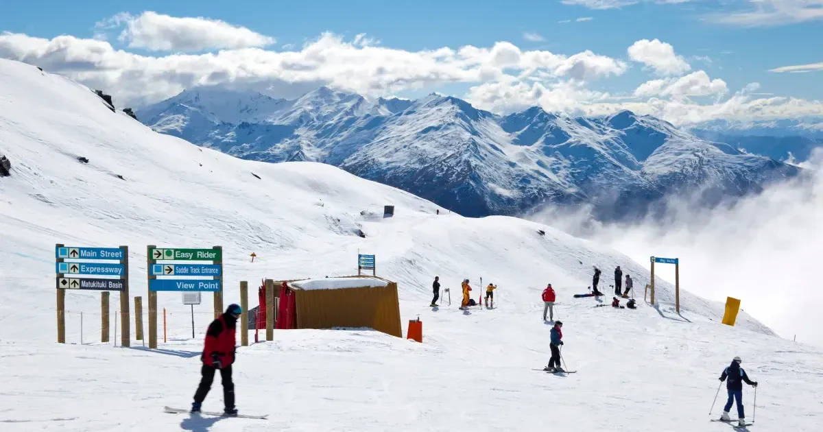 Snowboard riders sliding down slope at winter mountain resort