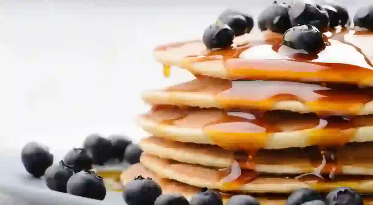 Delicious pancakes close up, with fresh blueberries and maple syrup