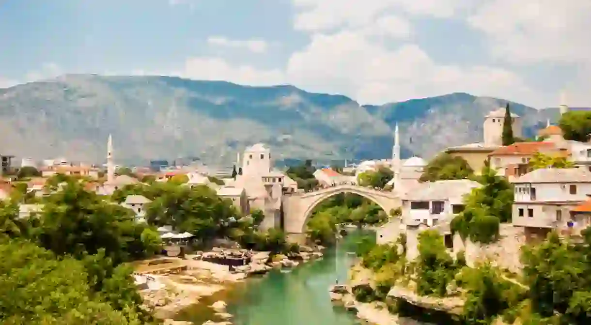 Beautiful view on Mostar city with old bridge, mosque and ancient buildings on Neretva river in Bosnia and Herzegovina