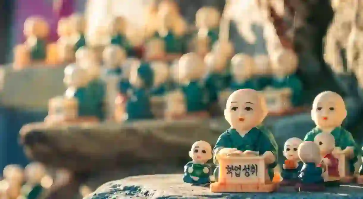 figurines scattered around the rocks of Haedong Yonggungsa Temple in Busan, South Korea. The figurines are meant to encourage academic achievement