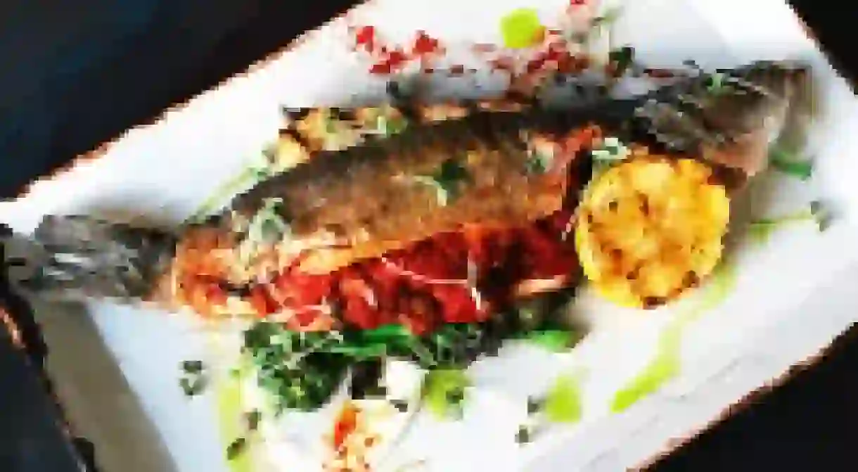 Signature Branzino with sugo puttanesca, spiced rapini, grilled house-made focaccia