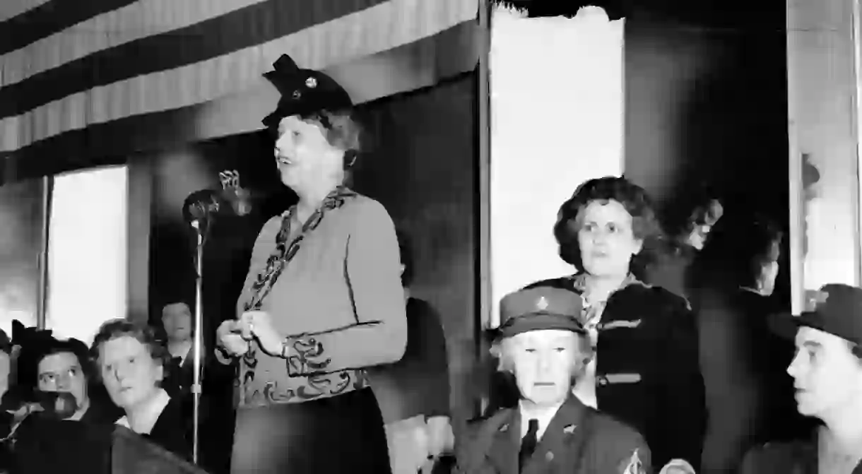 Eleanor Roosevelt speaks to a war-time audience while Rose Pesotta and others listen.