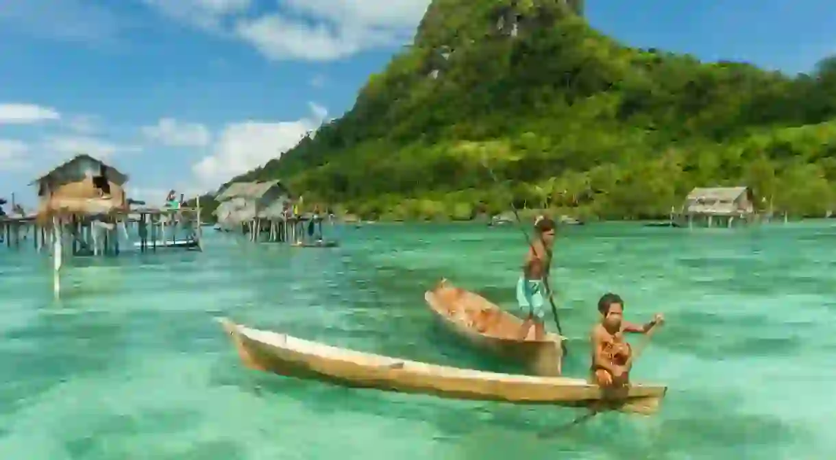 Sea Gypsy kids on a canoes in Bodgaya Island, Sabah Borneo, Malaysia