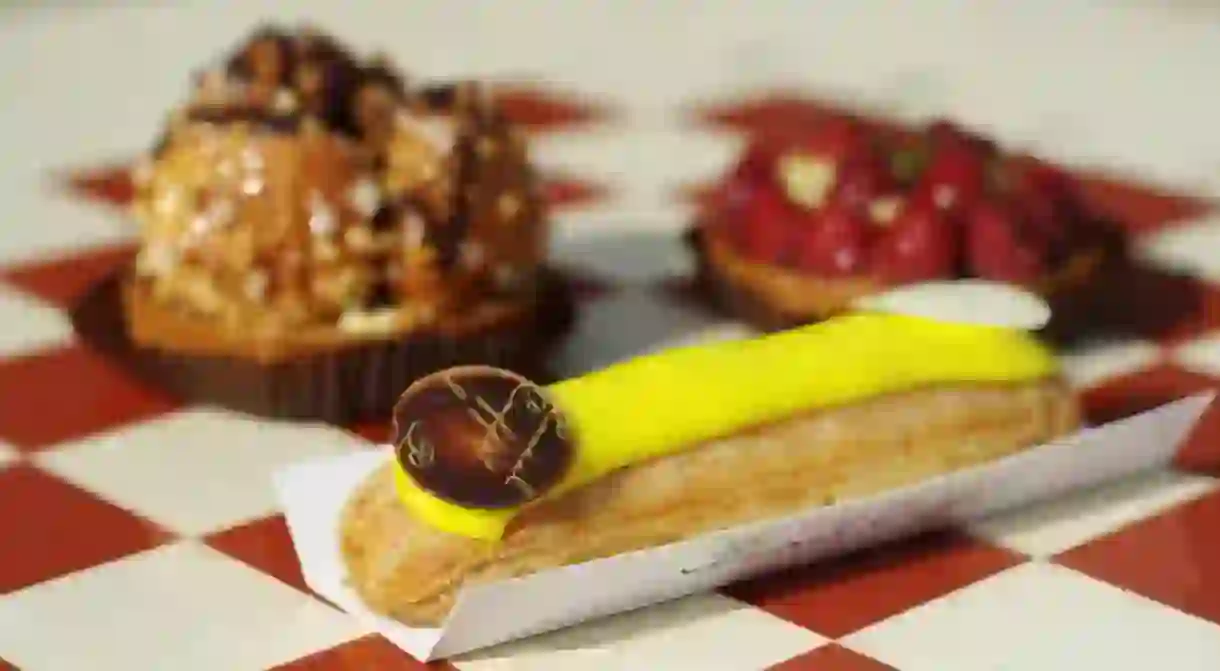 Eclair and tarts on checkerboard surface