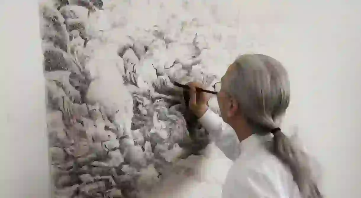 Liu dan painting a portion of a landscape,