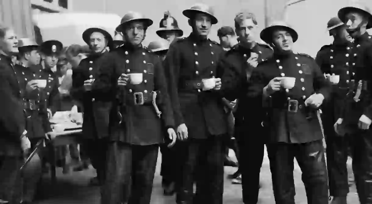 WWII-era London firemen and Auxiliary Fire Service firefighters take a tea break.