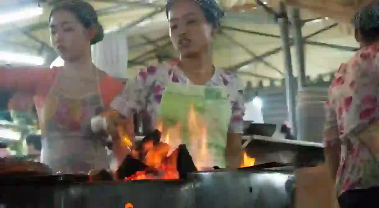 Vietnamese cooks in a steaming hot street food marquee