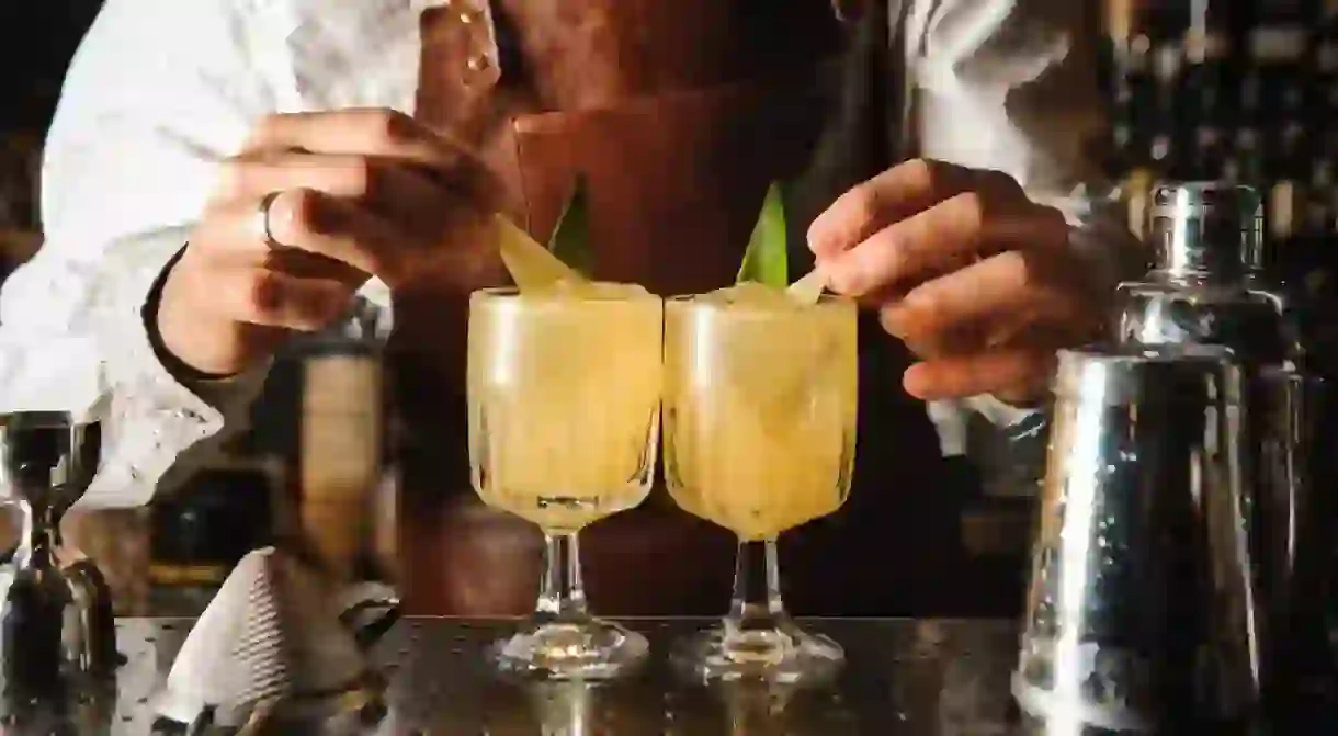 A Barman decorating cocktail with lemon