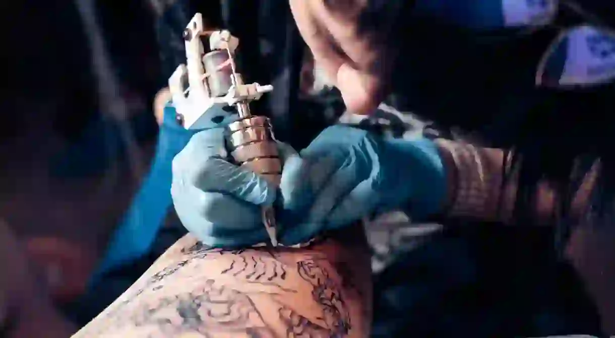 Tattoo Artist Outlining a Large Tattoo