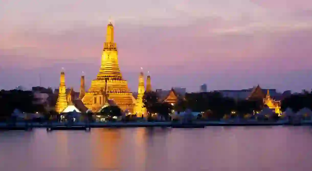 Wat Arun glows in the pink twilight by the Chao Phraya River, Bangkok