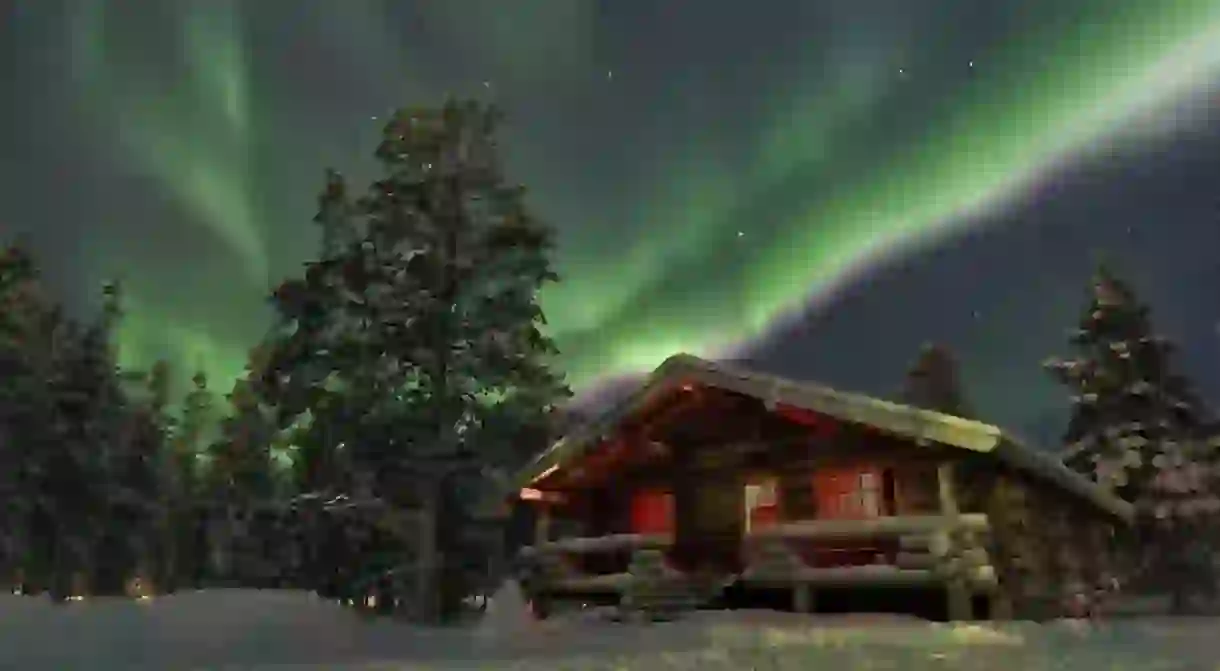 The northern lights above a wooden chalet