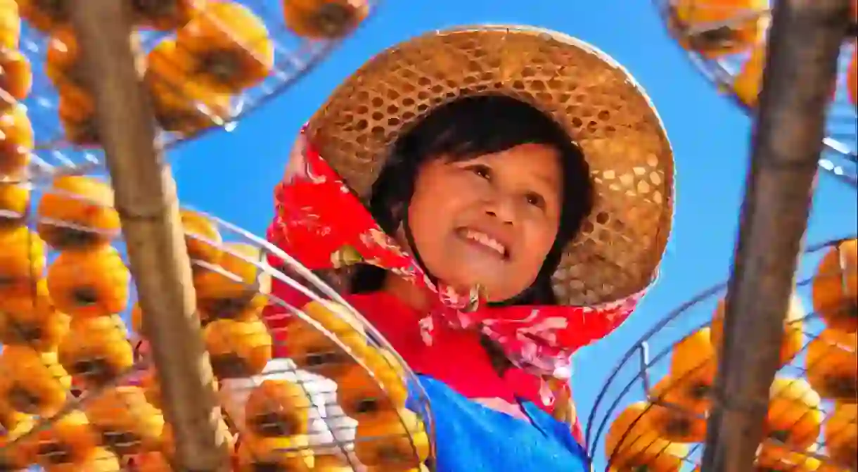 A Hakka woman in a traditional hat and scarf