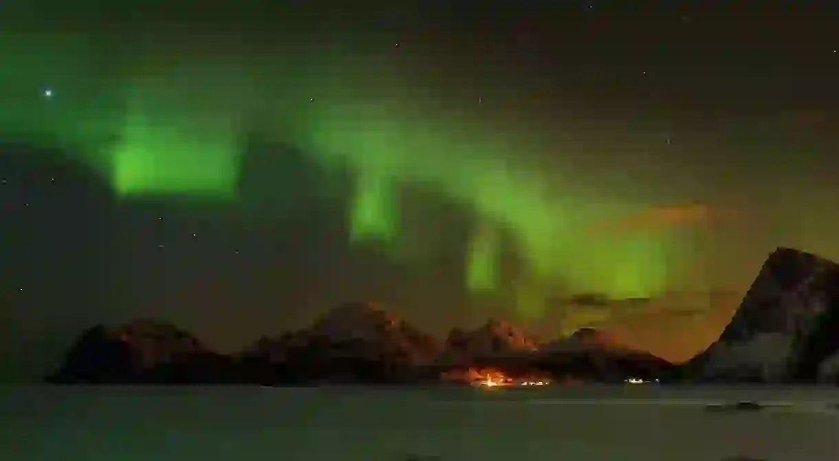 An aurora borealis over the mountains in the Lofoten islands, Norway