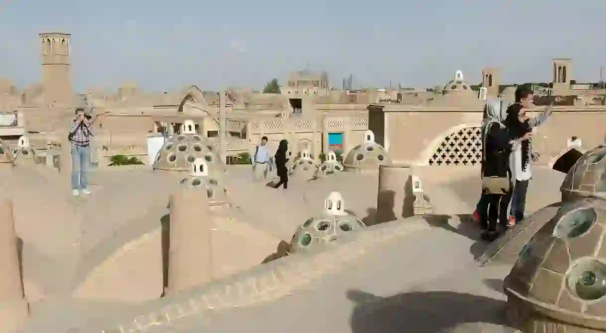 Tourists explore the rooftops of Kashan