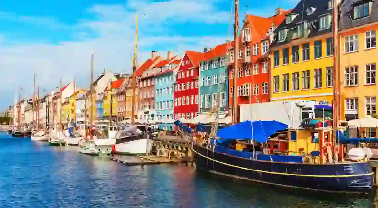 Scenic summer view of Nyhavn pier with colour buildings, ships, yachts and other boats in the Old Town of Copenhagen, Denmark