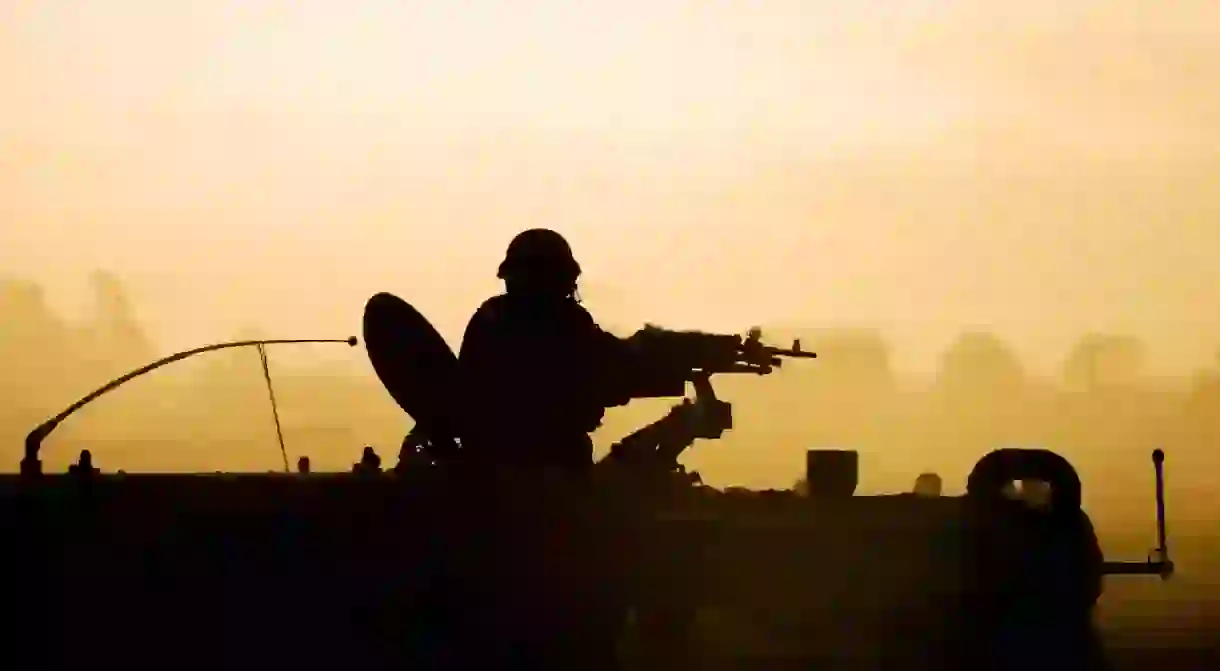 An army soldier preparing his tank and weapons at sunset