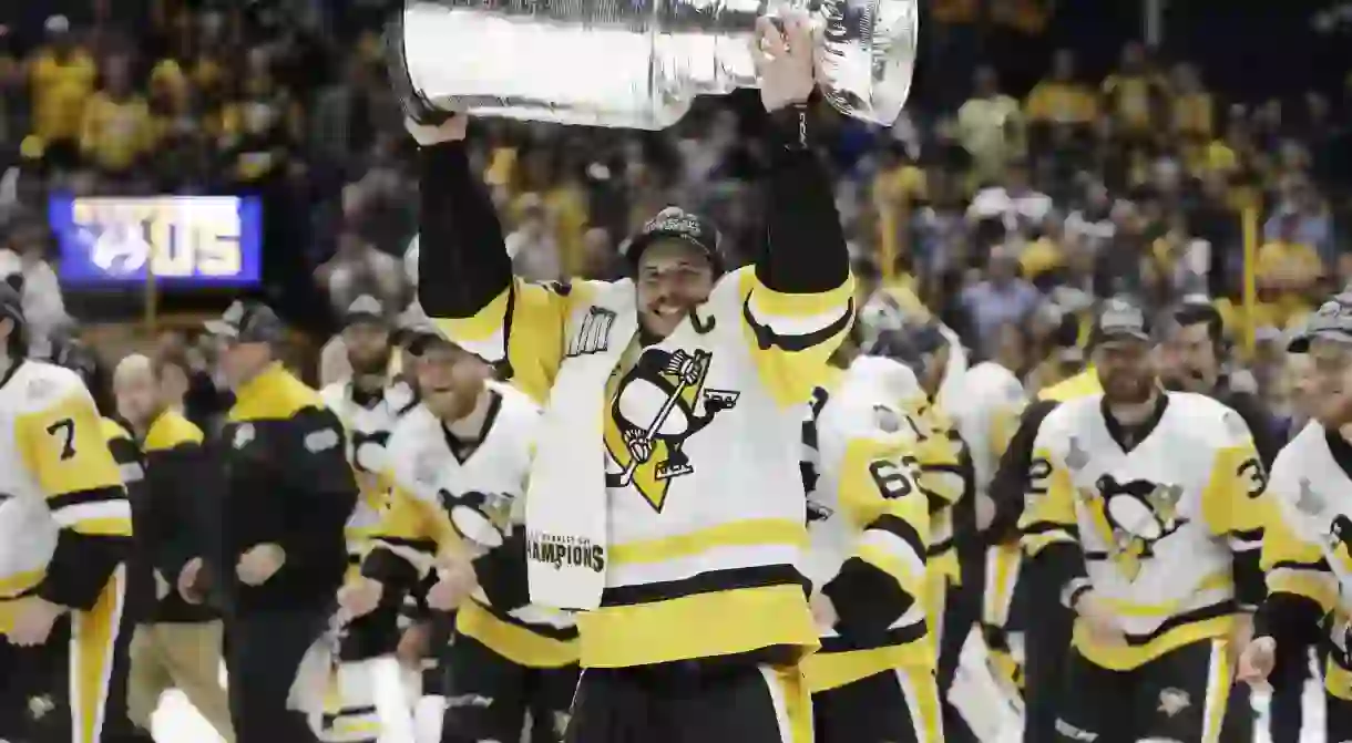 Pittsburgh Penguins captain Sidney Crosby hoisting the Stanley Cup.