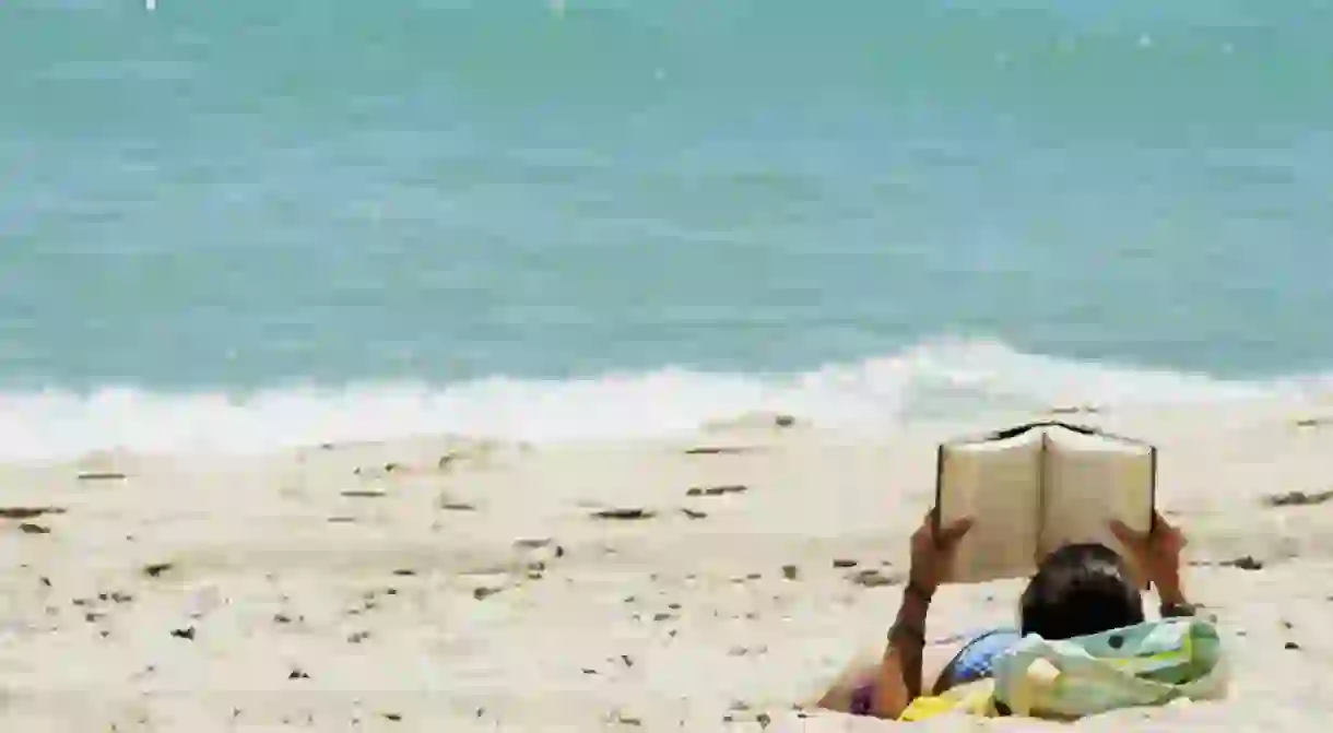 Reading on the beach. Photo: Jgoge123/Flickr