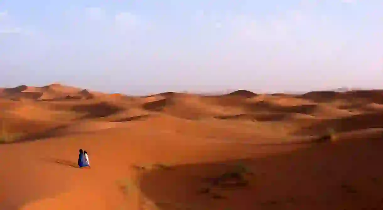 Two people walking across the desert