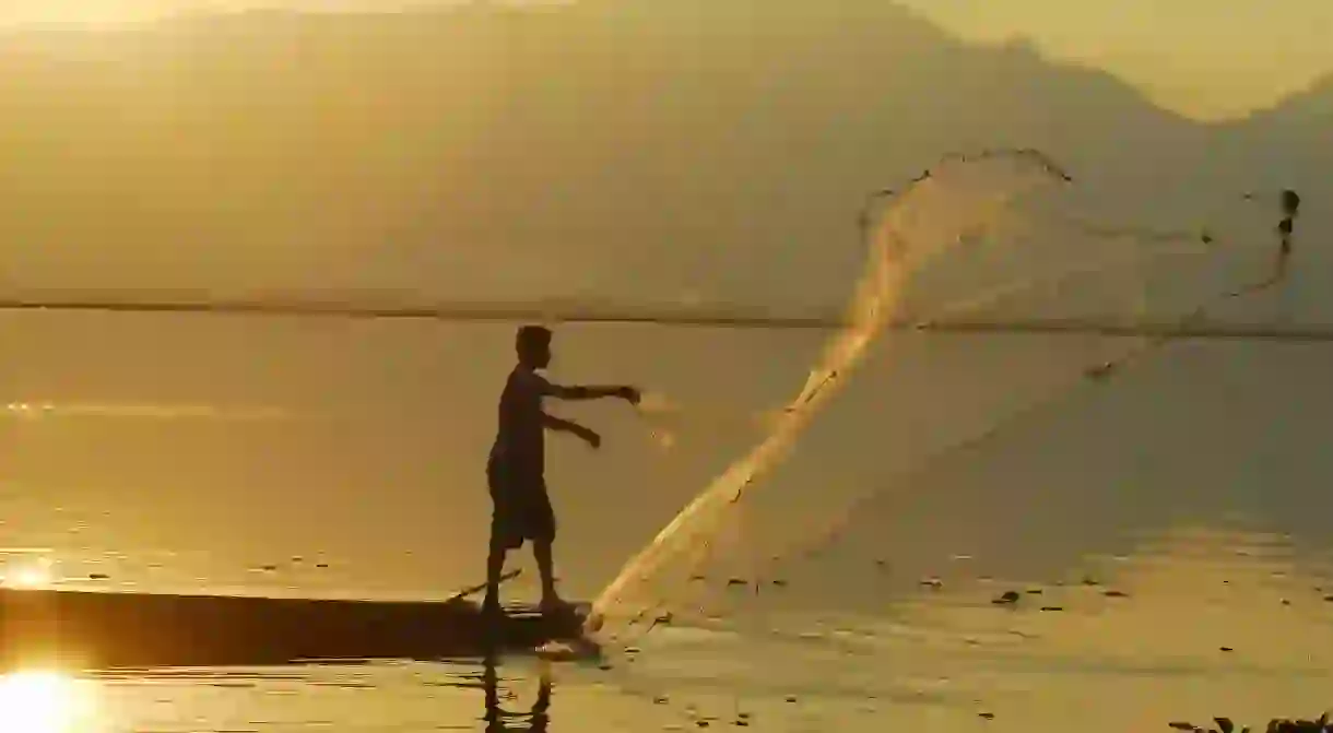 Thai fisherman casts his net