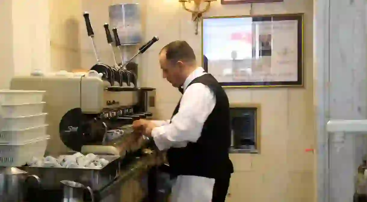 A barista expertly prepares the orders at Caffè Gambrinus