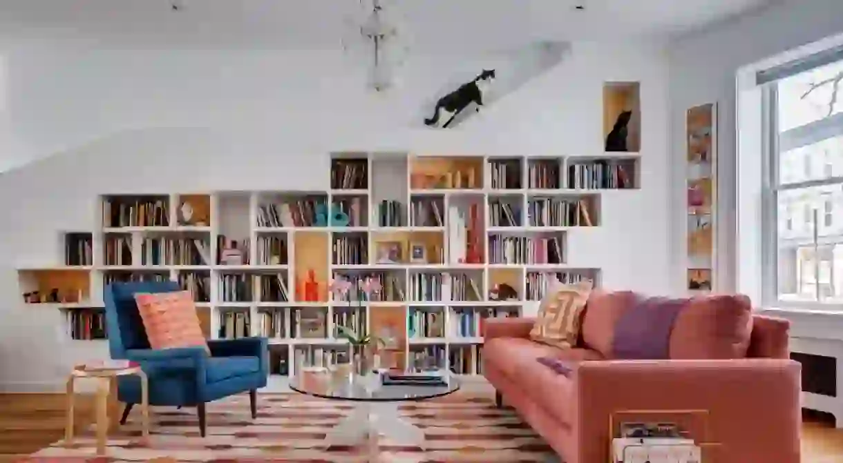 The bookshelf has a platform above it from where the cats can view the daily goings-on