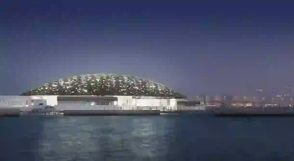 Louvre Abu Dhabis exterior with Abu Dhabis skyline (night)