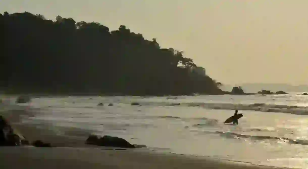 Surfer paddling out in Nuqui, Colombia