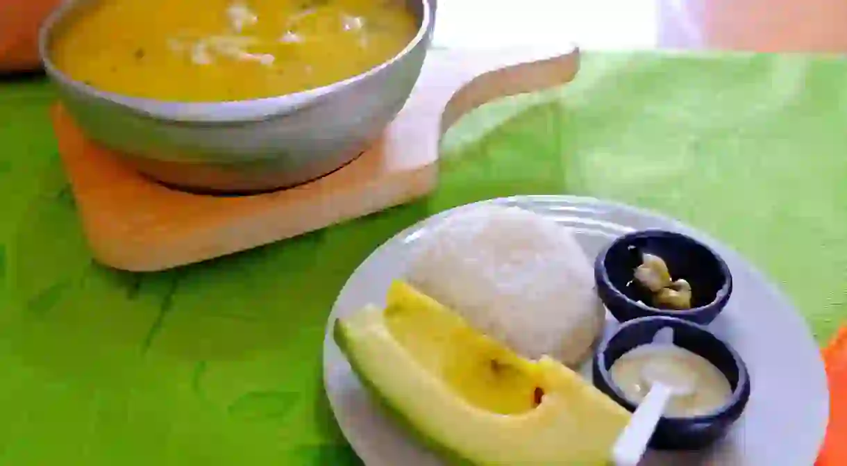 A full Colombian-style ajiaco with rice and avocado