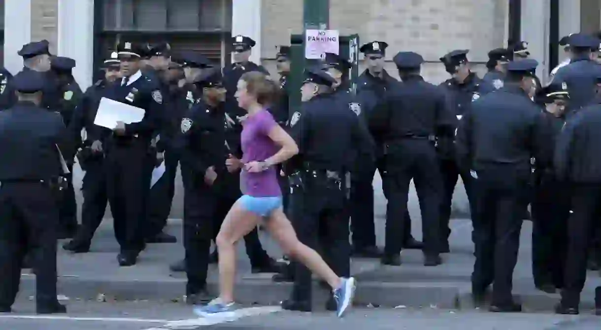 A runner goes past NYPD officers during the 2016 NYC Marathon