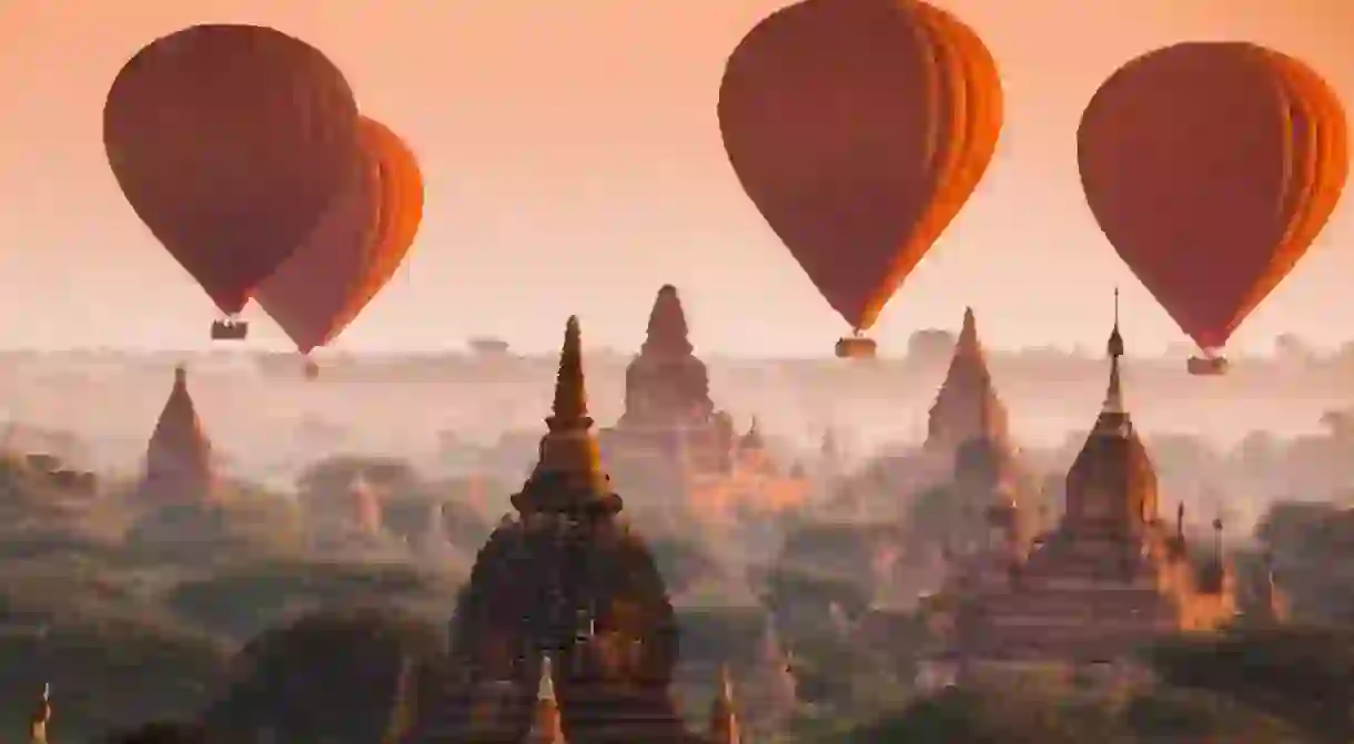 Hot air balloons rise over misty Bagan early in the morning