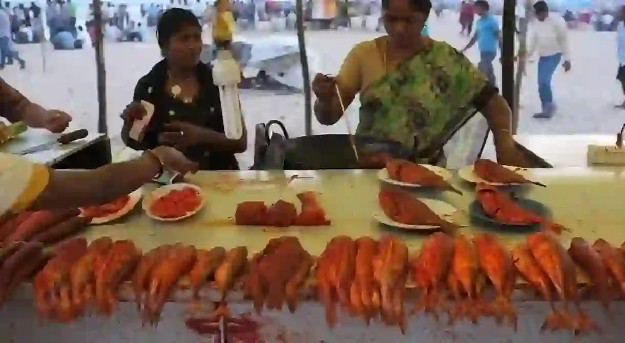 A vendor making fried fish at a stall in Chennais Marina Beach 