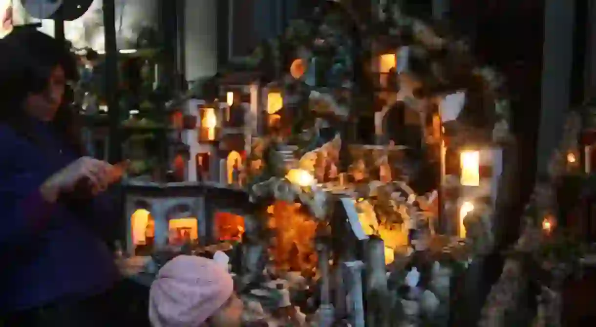 A child gazes at a nativity scene in San Gregorio Armeno Street.