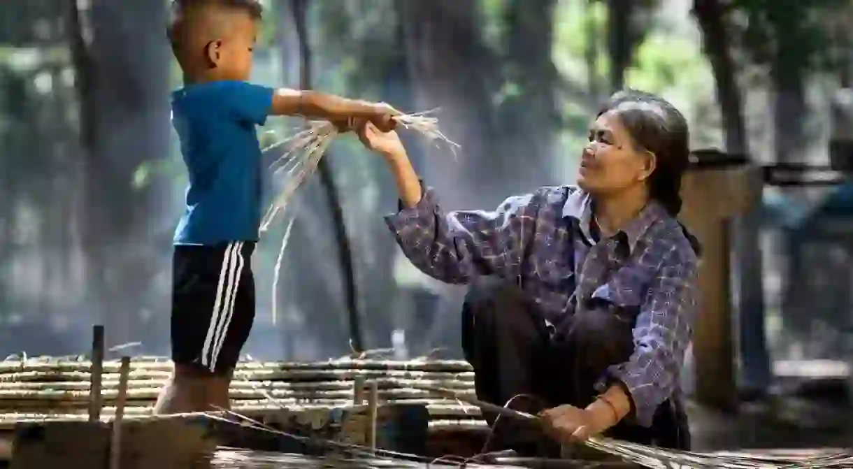 An Indonesian boy helps his grandmother