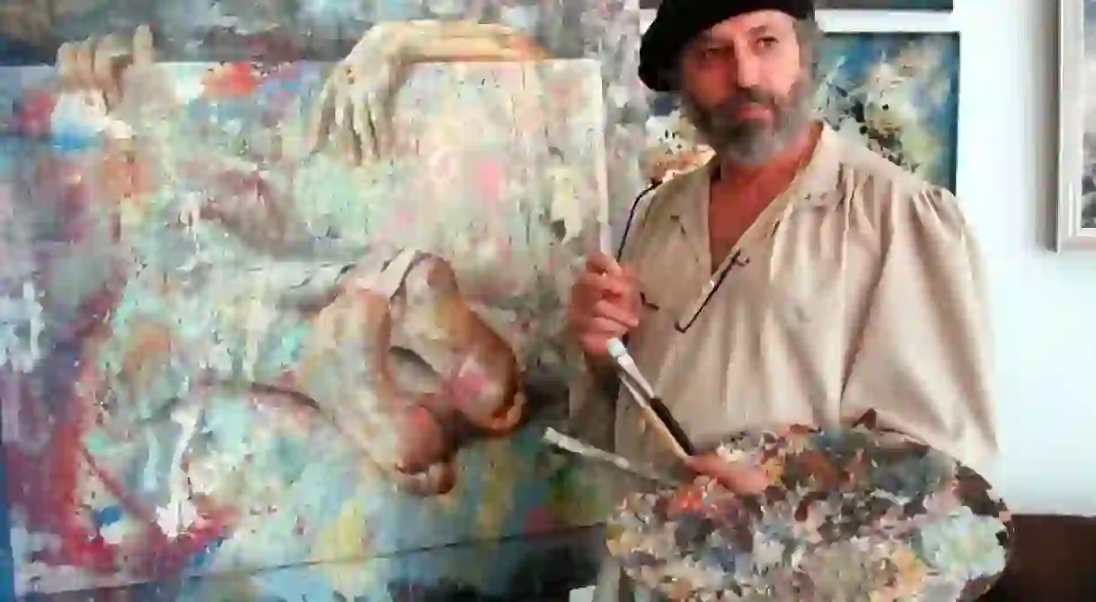 Zoro Mettini painting in a beret