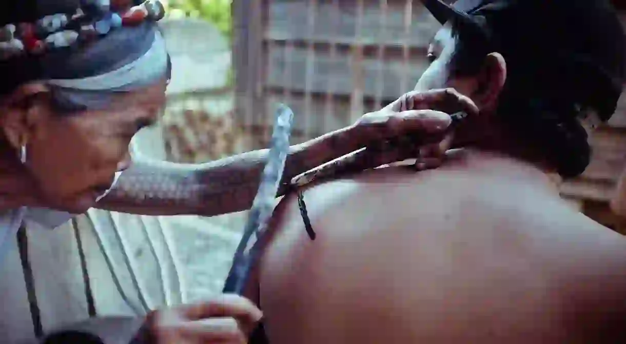 Man getting tattooed by Whang Od