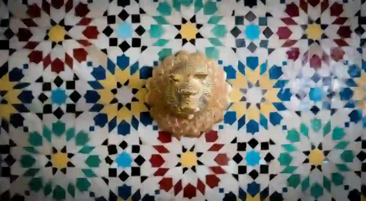 Lion-head water tap against colourful Moroccan tiles