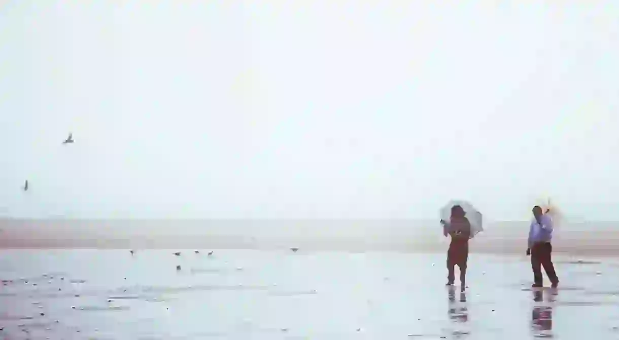 A couple enjoying some alone time on a rainy day in Chennais Marina Beach