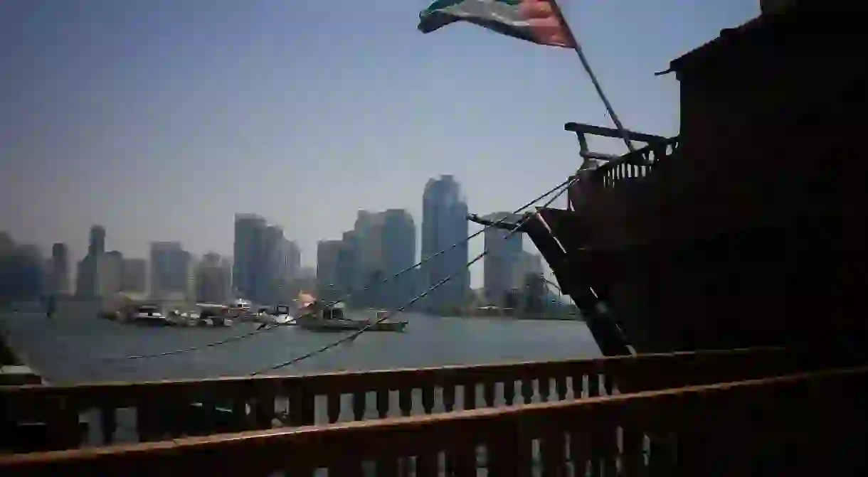 The UAE flag flying off of a traditional dhow boat