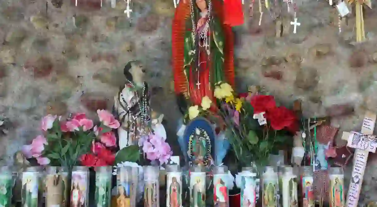 A statue of Juan Diego at the feet of the Virgin of Guadalupe │