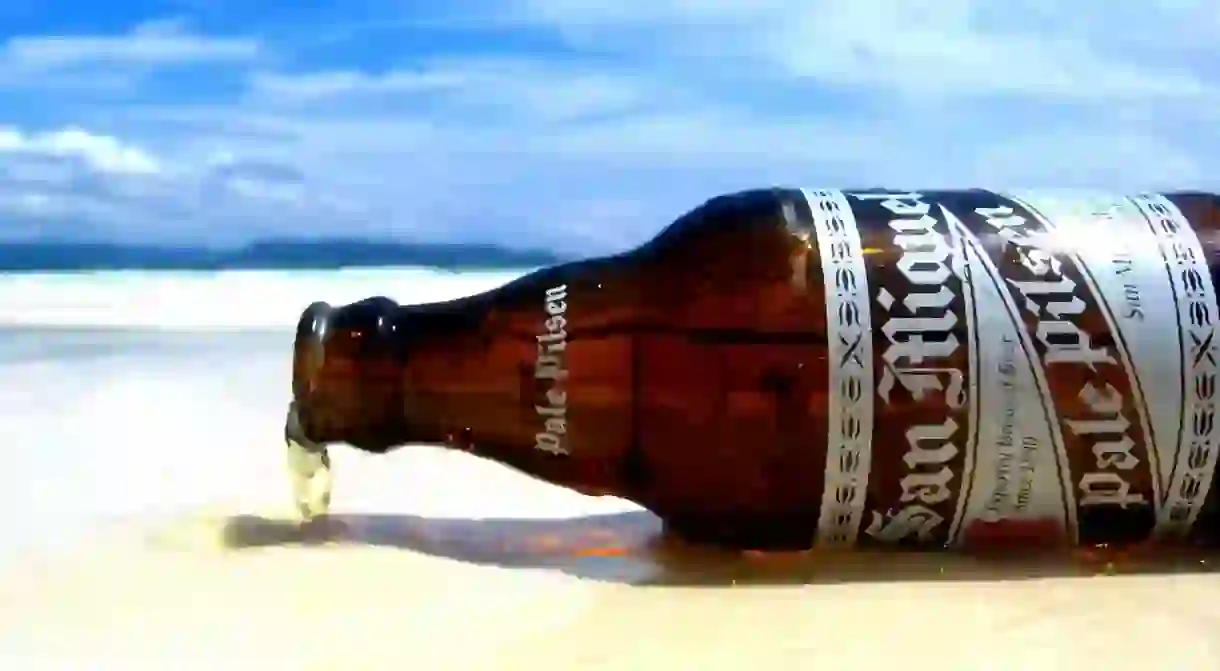 Bottle of San Miguel Pale Pilsen on the beach