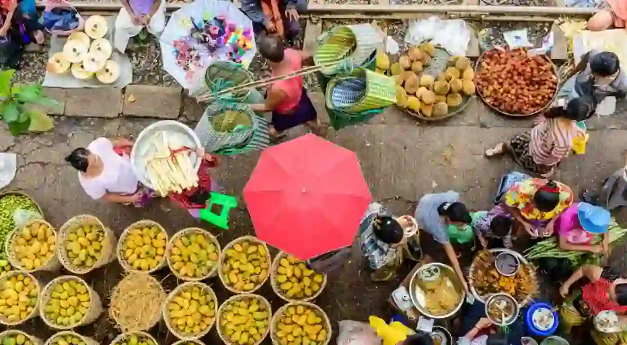 Market sellers and goers line the railway at Da Nyin Gone Market near Yangon, Myanmar