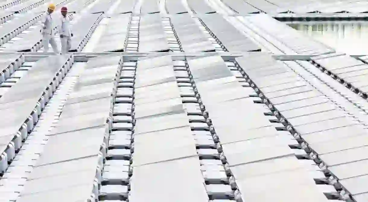 Two engineers stand on floating solar panels