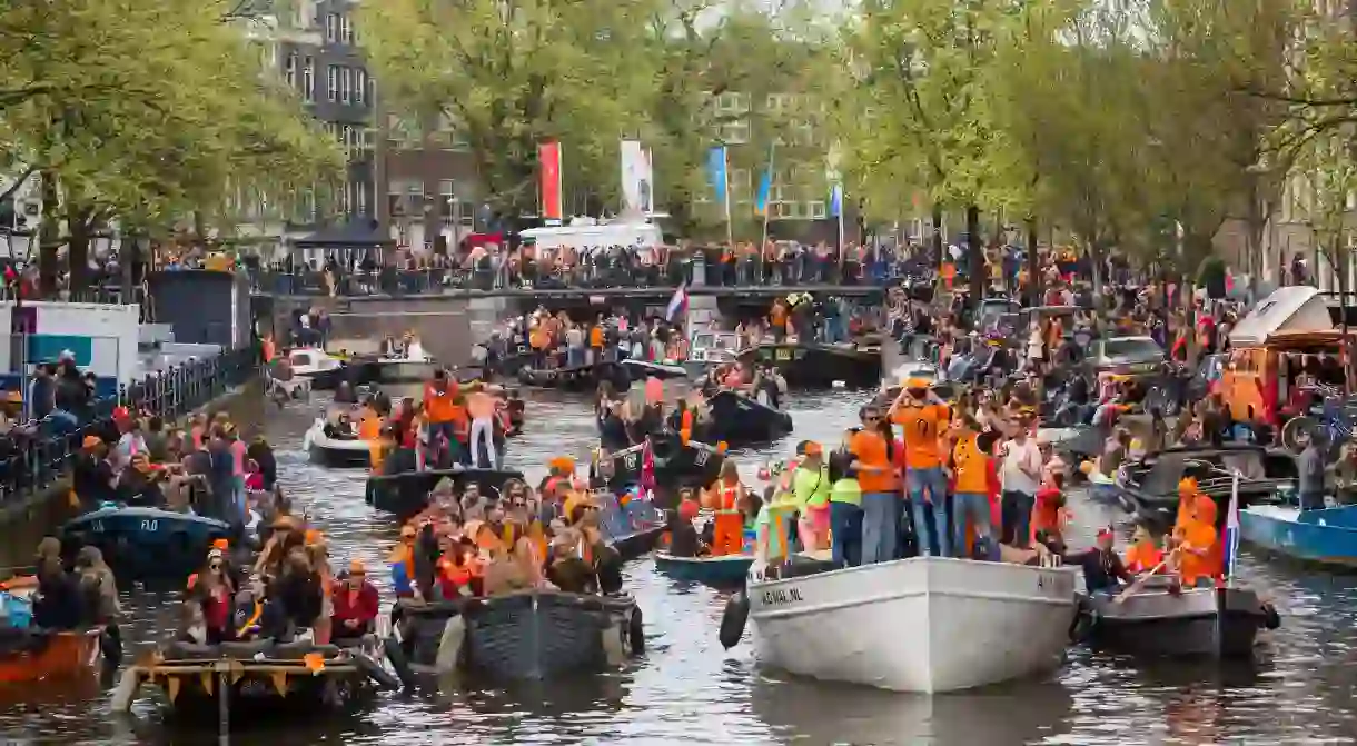 Boat parade in the canals of Amsterdam for annual Kings Day, The Netherlands