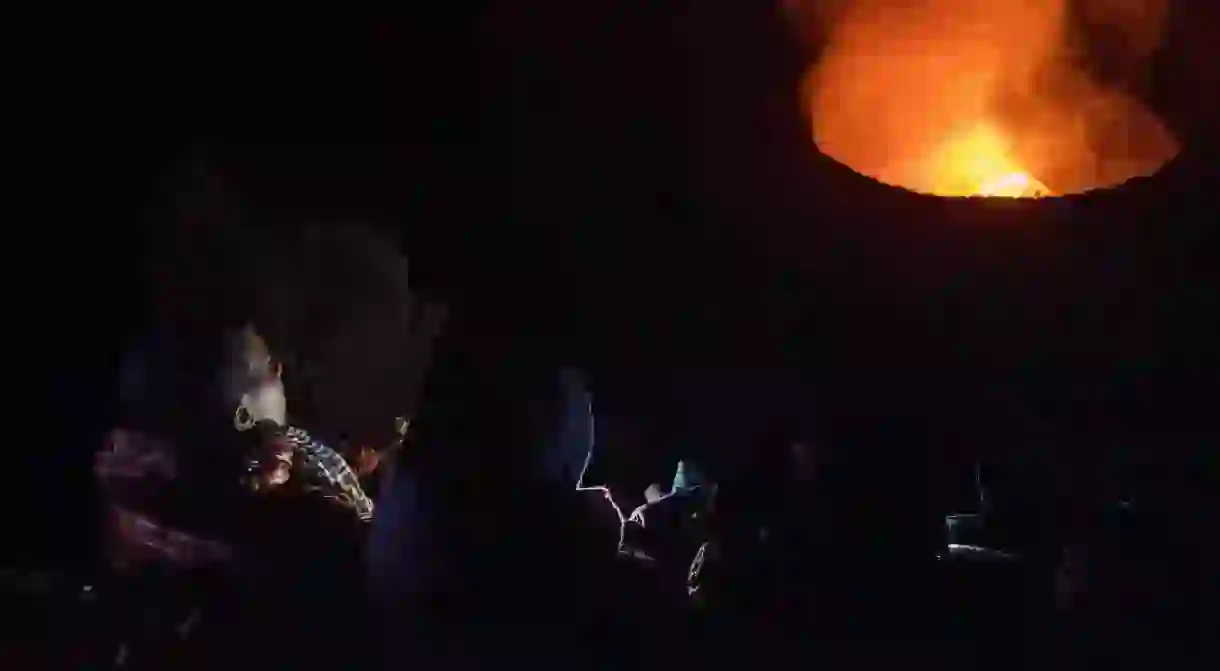 Ugandan adventurers watching the active volcano atop Mount Nyirangogo in Democratic Republic of Congo