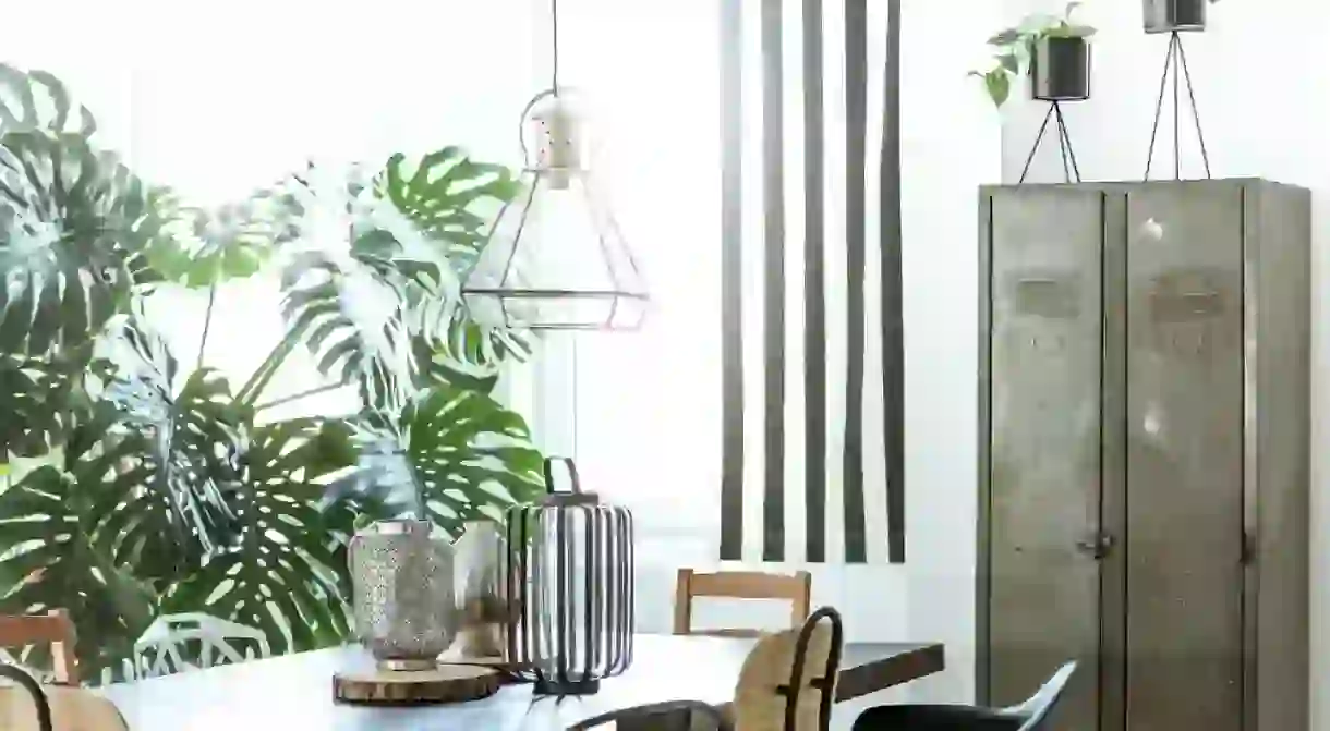 White, industrial dining room with metal wardrobe and wood table