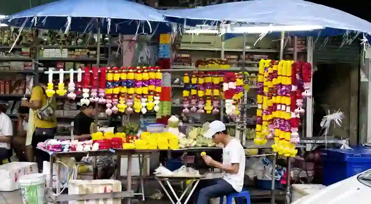 A local making flower garlands in Bangkok