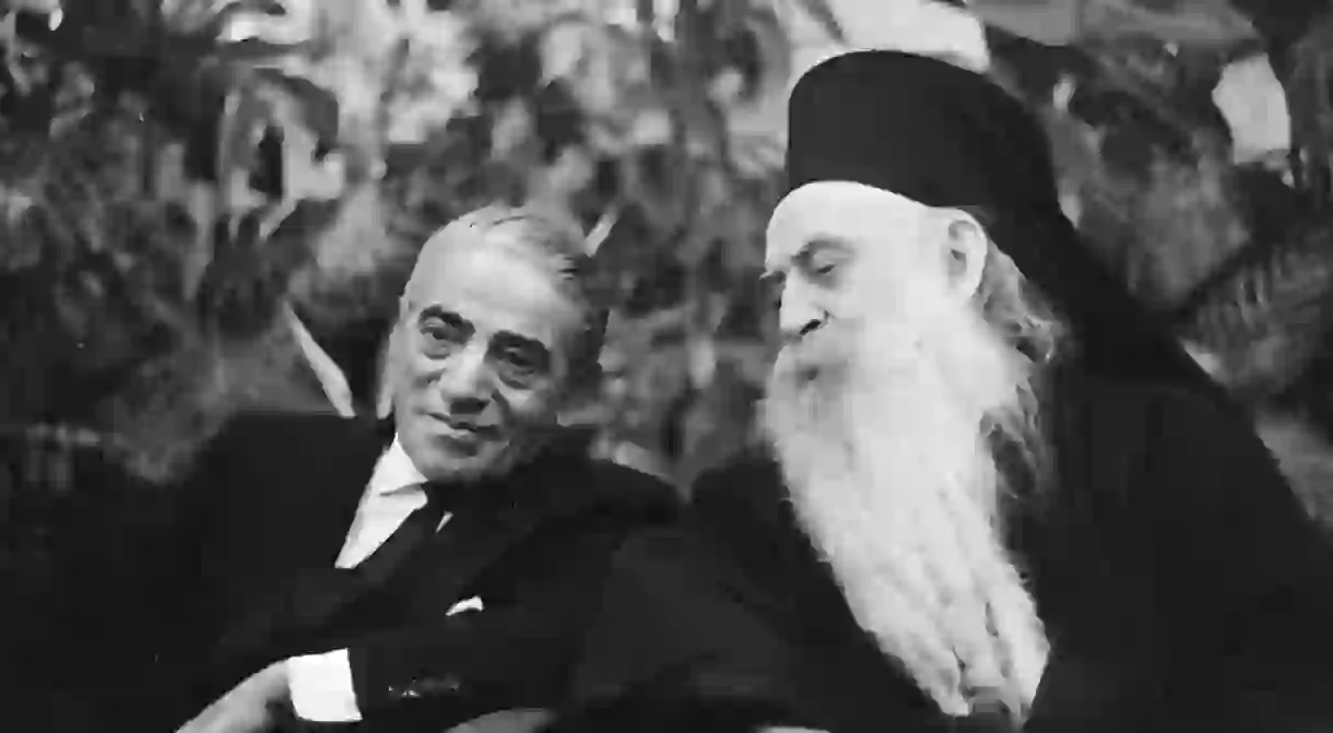 Onassis (left) talks with Patriarch Athenagoras in the VIP room at Schiphol