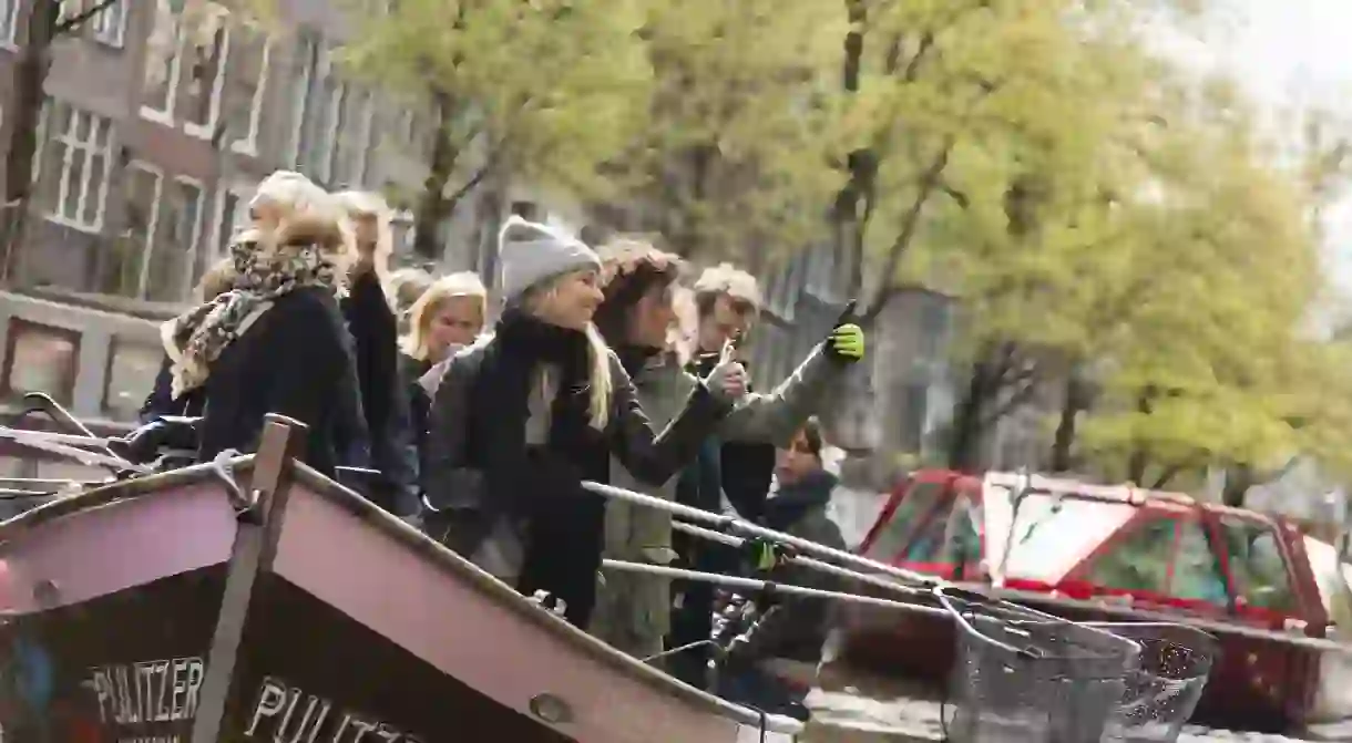 People fishing for plastic during a boat tour with Plastic Whale