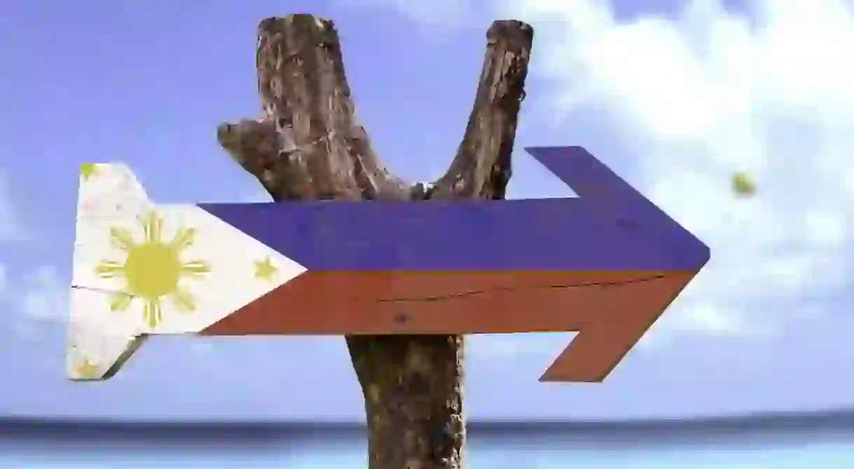 Philippines wooden sign with a beach on background